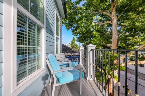 a porch with a blue chair and a tree at Hosteeva Chic Urban Retreat w Pool Steps to St Charles Ave and Near Bourbon St in New Orleans