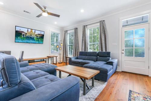 a living room with blue couches and a table at Hosteeva Chic Urban Retreat w Pool Steps to St Charles Ave and Near Bourbon St in New Orleans