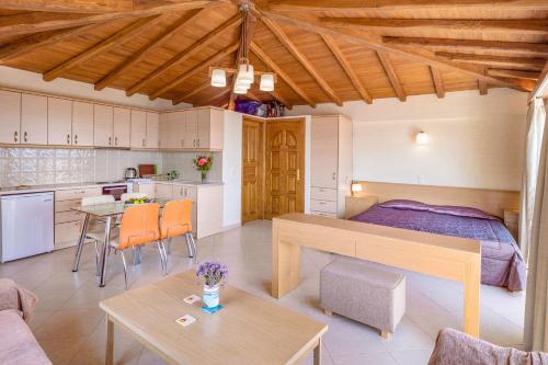 a room with a bed and a table and a kitchen at PENNY LUXURY APARTMENTS in Kokkari