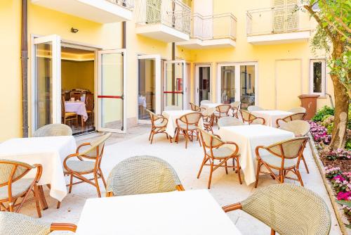 a group of tables and chairs on a patio at Hotel Centrale in Garda