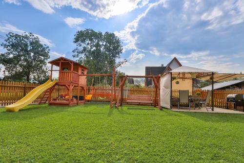 a backyard with a playground with a slide and a gazebo at Słoneczny Dworek in Białka Tatrzańska