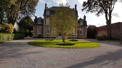 dom z drzewem przed nim w obiekcie VILLA VARENTIA w mieście Villers-Bretonneux