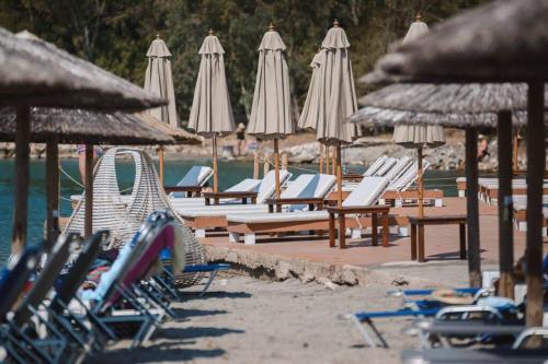 a group of lounge chairs and umbrellas on a beach at Palmeira Studio in Preveza