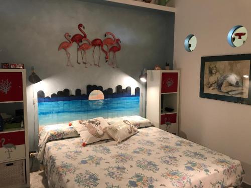 een slaapkamer met een bed met rode flamingo's aan de muur bij Casa Micheletti in Rodia