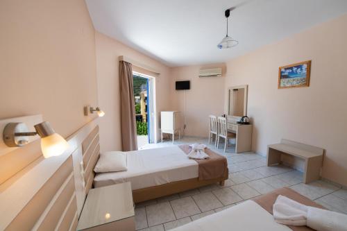 a bedroom with a bed and a desk in a room at Surf Hotel in Vasiliki