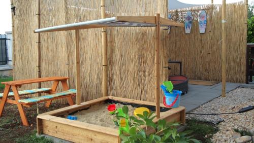 a sandbox with a chair and a sandpit in a garden at Studio apartment Gray in Šibenik