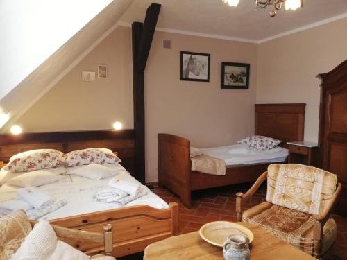 a bedroom with two beds and a table and a chair at Siedlisko Sabinowo in Węgorzewo