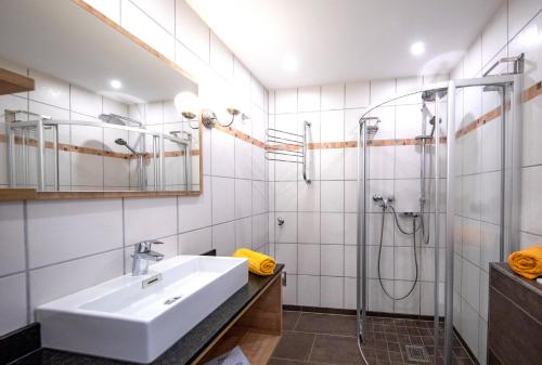 ein Bad mit einem Waschbecken und einer Dusche in der Unterkunft Alpenstyle Apartment Nina in Kaprun