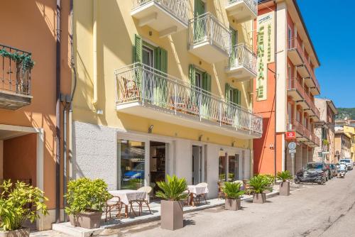 a street in a city with chairs and plants at Hotel Centrale in Garda