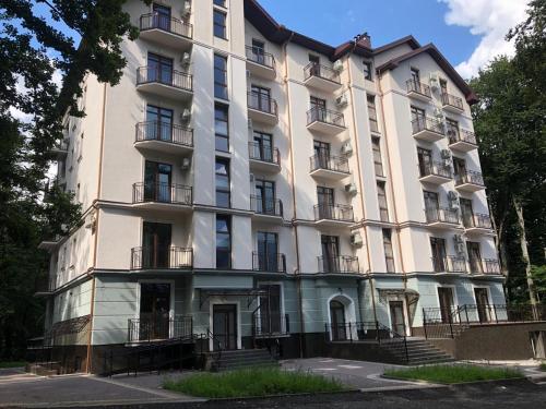 a large white building with balconies on a street at Апартаменти КАРПАТИ in Karpaty