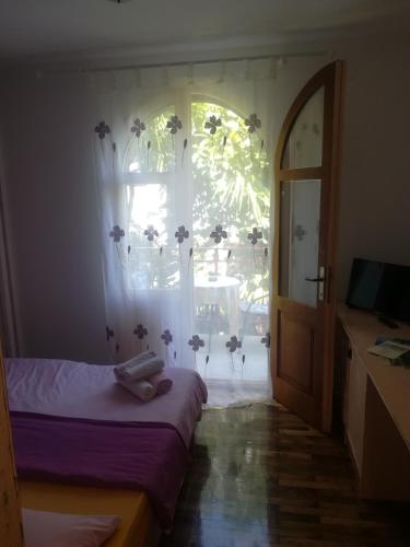 1 dormitorio con cama, ventana y TV en Romantic room with balcony, en Lovran