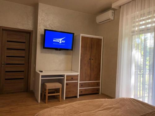 a bedroom with a flat screen tv on the wall at Апартаменти КАРПАТИ in Karpaty