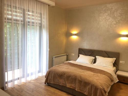 a bedroom with a bed and a large window at Апартаменти КАРПАТИ in Karpaty