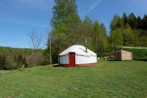 a yurt with a red door in a field at Jurtos nuoma in Kartena