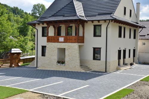 una casa con techo de gambrel en un estacionamiento en Pensiunea ARMONIA, en Văleni