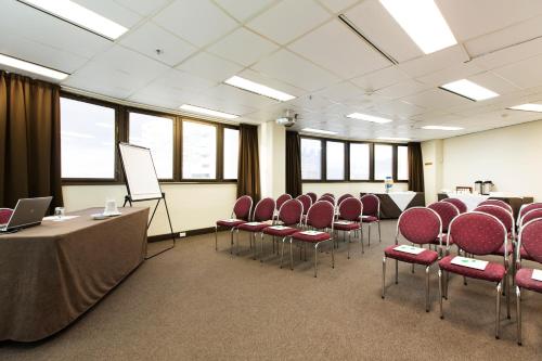 a conference room with chairs and a podium and a whiteboard at Hotel Grand Chancellor Townsville in Townsville