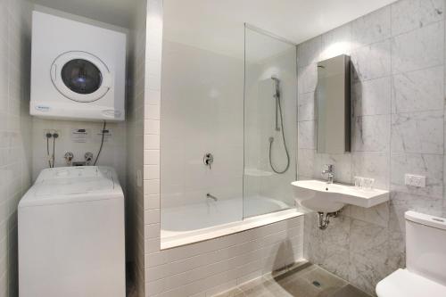 y baño con ducha, aseo y lavamanos. en Adara Hotel Richmond en Melbourne