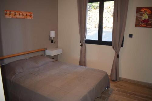a bedroom with a bed and a window at Les terrasses du Bruguet in Rosières