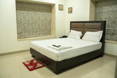 a bedroom with a large bed with white sheets at NK7 Guest House in Kolkata