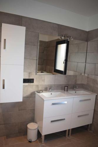 une salle de bain avec un lavabo blanc et un miroir dans l'établissement Les terrasses du Bruguet, à Rosières