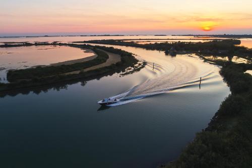 an aerial view of a boat in the water at sunset at Club del Sole Tenuta Primero Grado Family Collection in Grado