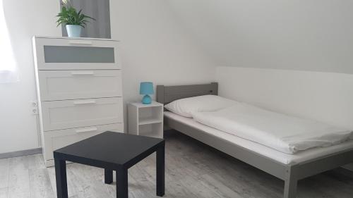 um pequeno quarto com uma cama e uma mesa em Domb Apartmanok em Sukoró