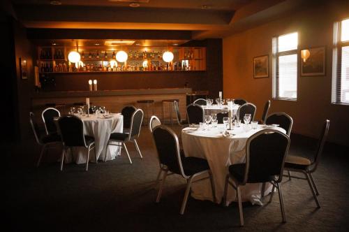 a dining room with tables and chairs and a bar at Spinifex Hotel in Derby