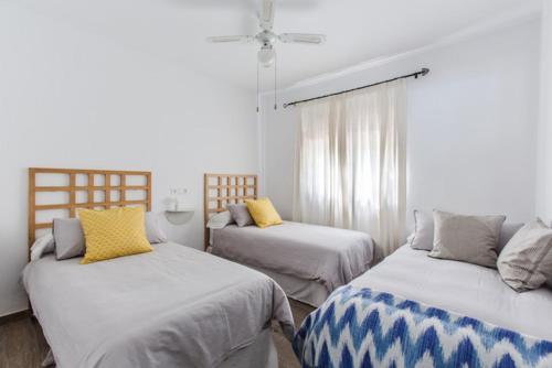 1 dormitorio con 2 camas con almohadas amarillas en Finca andaluza Los Molinos, en Estepona
