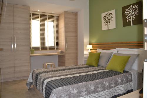 a bedroom with a large bed with green walls at Filia Luxury Apartments in Chania Town