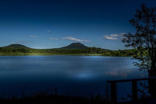 a view of a lake with mountains in the background at Apartmány Poslův Mlýn in Doksy