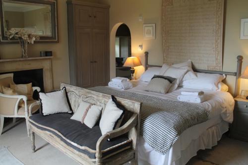 a bedroom with a large bed and a chair at Roundhill Farmhouse in Bath
