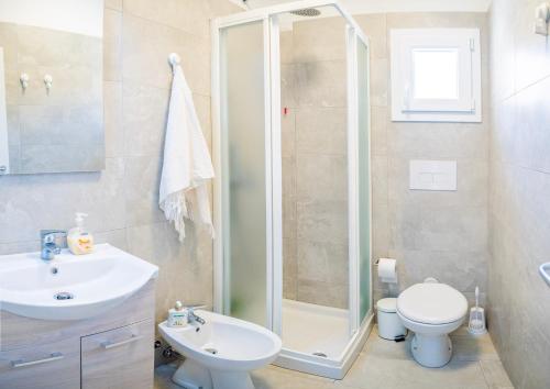 a bathroom with a shower and a toilet and a sink at Paradiso Pool Apartments by DomusAway in Costa Paradiso
