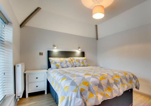 a bedroom with a bed with a yellow and gray comforter at Gwynle Townhouse, Bala in Bala