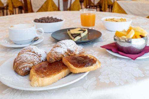 a table with a plate of pastries and a cup of coffee at Hotel Tiglio in Rimini