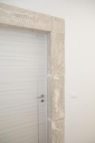 a white garage door with a stone wall at Residenza Cappelli - Case Vacanze in San Demetrio neʼ Vestini