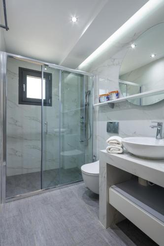 a bathroom with a glass shower and a sink at BISALTAE SEASIDE SUITES in Keramoti