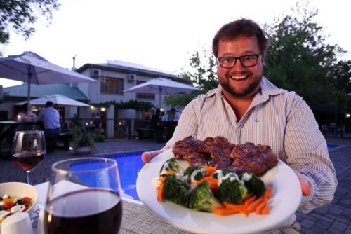 MiddelburgにあるCeltis Country Lodge & Restaurantの食卓を持つ男
