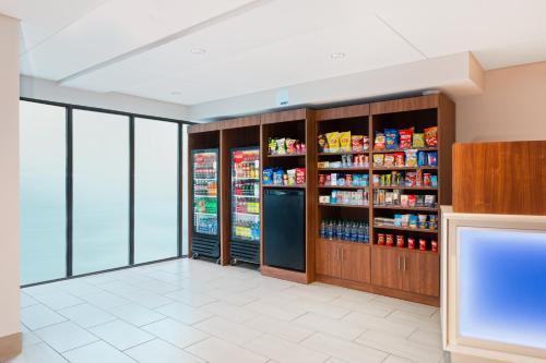 a store aisle with a refrigerator and shelves of food at Holiday Inn Express Ft Lauderdale Cruise-Airport by IHG in Fort Lauderdale