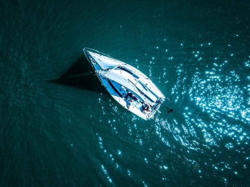 a boat in the water next to a black star at ALPENHOTEL TYROL - B&B - ADULTS ONLY - Alpines Lifestyle-Konzepthotel - dog friendly in Pertisau