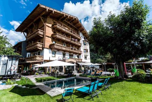ein Hotel mit einem Pool vor einem Gebäude in der Unterkunft Alpenhotel Tyrol - Konzepthotel - adults only in Pertisau