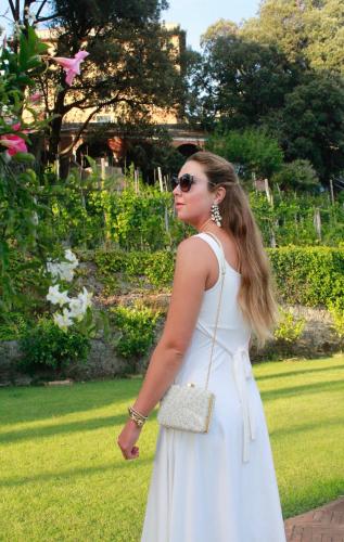 a woman in a white dress with a purse at Villa Agnese in Sestri Levante