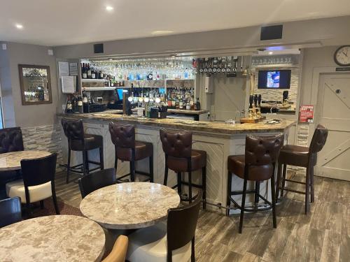 um bar com mesas e cadeiras num restaurante em The Blue Bell Crookham em Cornhill-on-tweed