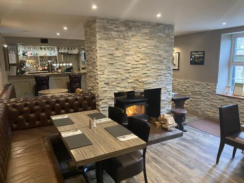 a restaurant with a fireplace and a table and chairs at The Blue Bell Crookham in Cornhill-on-tweed