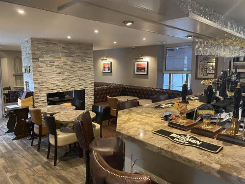 a restaurant with a bar and a fireplace at The Blue Bell Crookham in Cornhill-on-tweed