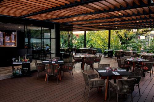 a restaurant with tables and chairs on a deck at Krystal Grand Suites Insurgentes in Mexico City