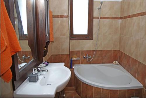 uma casa de banho com um lavatório e uma banheira em George’s Home em Sitia