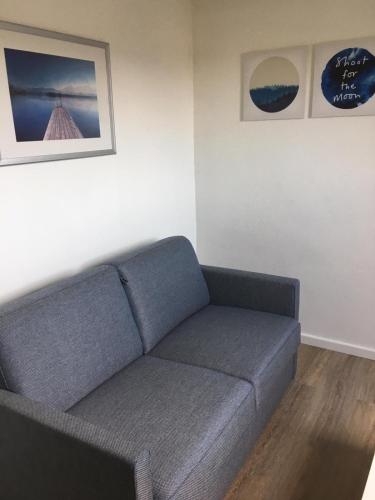 a living room with a blue couch and two pictures at Gaestehaus-Sylvie-Wohnung-2 in List