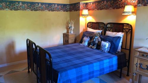 a bedroom with a blue bed with two teddy bears on it at Agriturismo La CasinaRosa in Loreto Aprutino