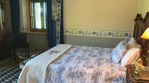 a bedroom with a bed with a blue and white blanket at Agriturismo La CasinaRosa in Loreto Aprutino