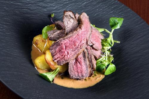 a piece of meat on a plate with lettuce at Hotel Tvrz Orlice in Letohrad